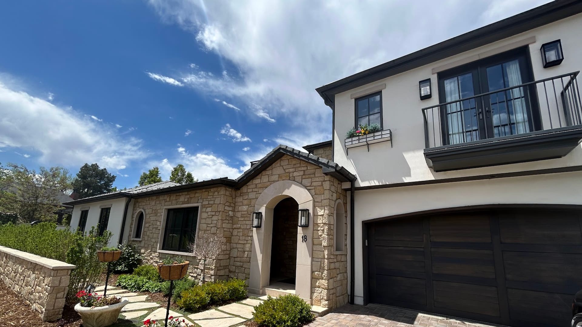 Original photo by Jackson Granger showing Cherry Creek-area residential architecture with stone details, landscaping, and blue sky.